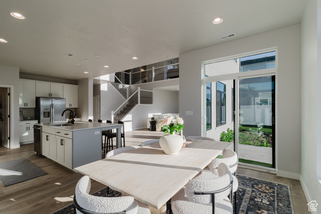 Dining space with stairs, wood finished floors, recessed lighting, and baseboards