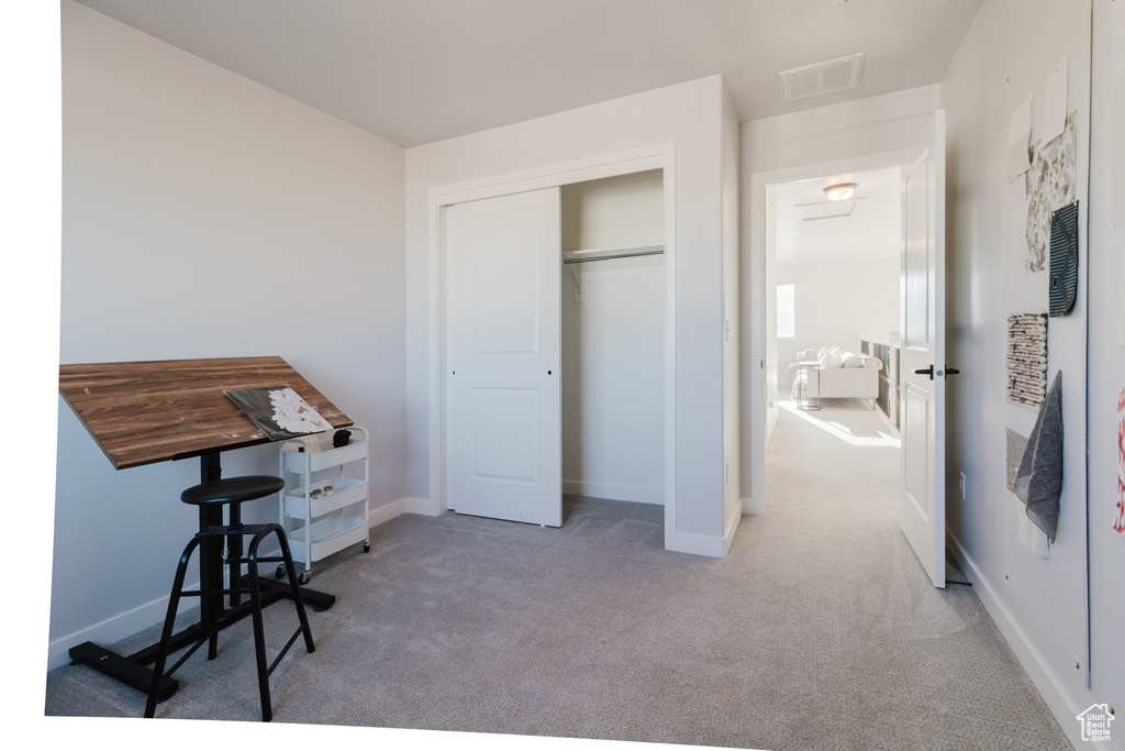 Carpeted bedroom with a closet and baseboards