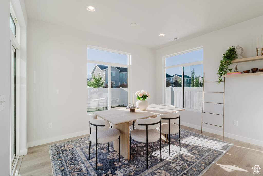 Dining room with light wood-style flooring, recessed lighting, and baseboards