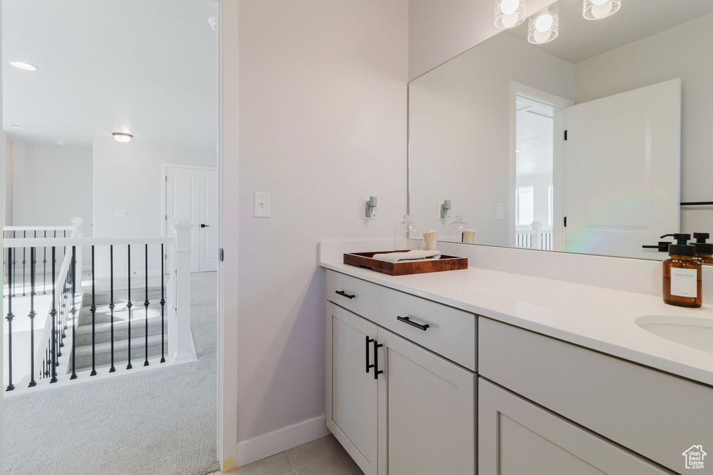 Bathroom featuring vanity, baseboards, and tile patterned flooring