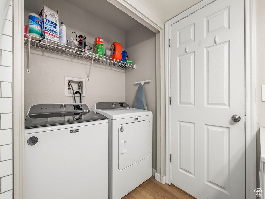 Laundry room featuring washing machine and dryer and light wood-style floors