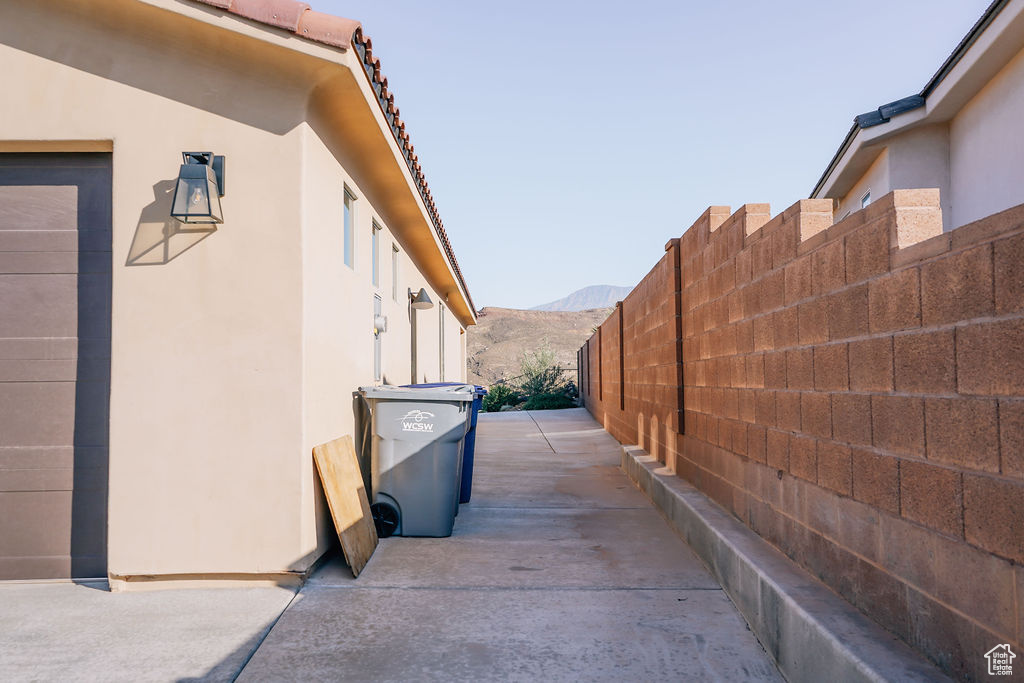 View of side of property with stucco siding, a mountain view, and a tiled roof