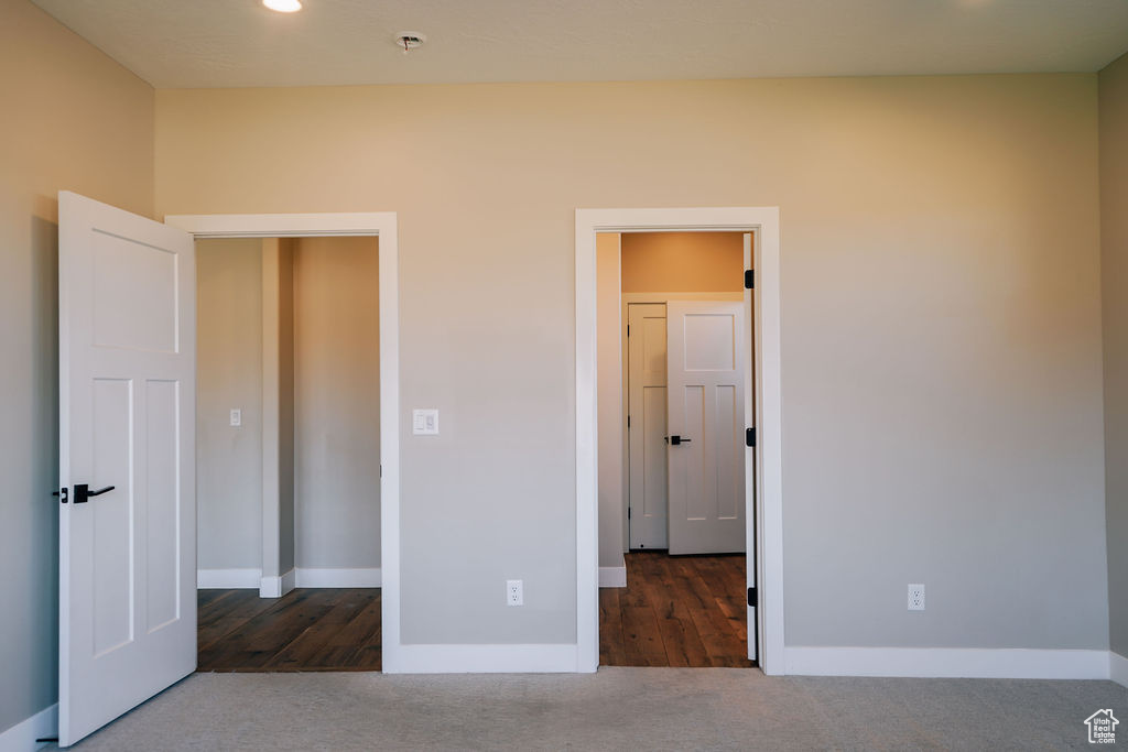 Unfurnished bedroom featuring baseboards and carpet
