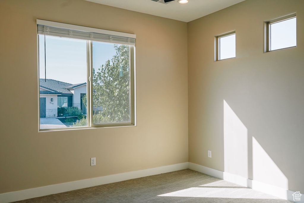 Carpeted spare room with baseboards and recessed lighting