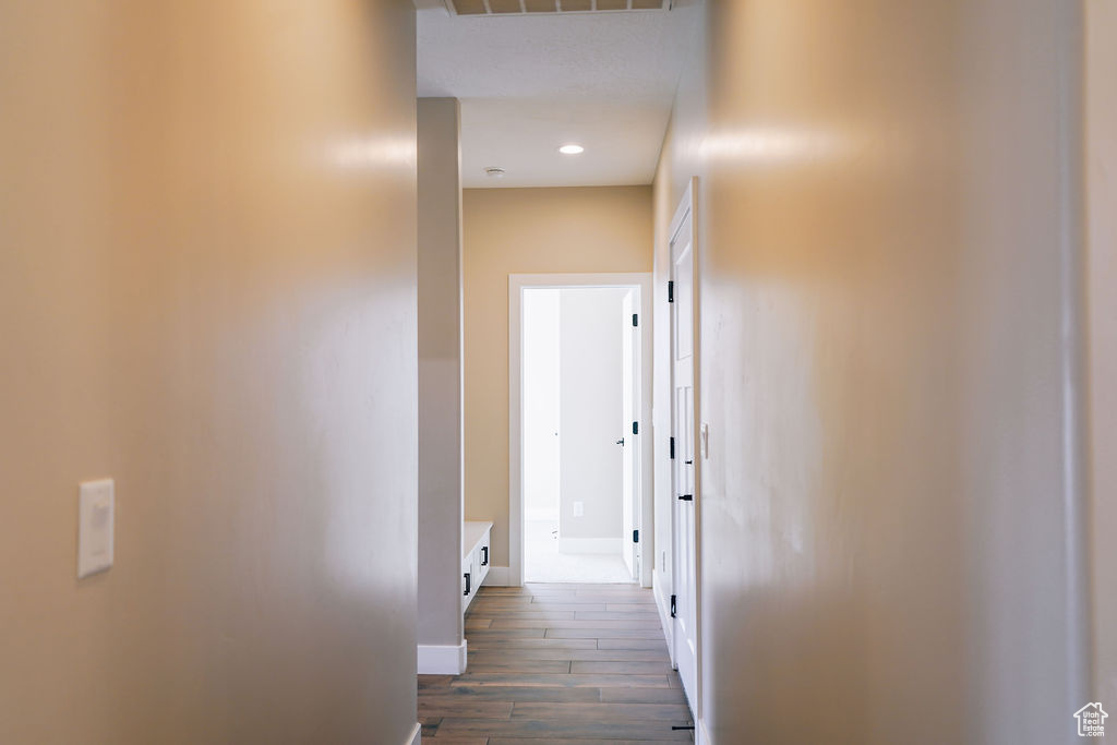 Hallway featuring baseboards, dark wood-type flooring, and recessed lighting