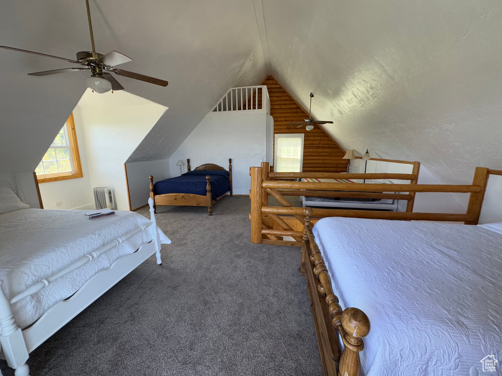 Bedroom featuring lofted ceiling, radiator, and carpet floors