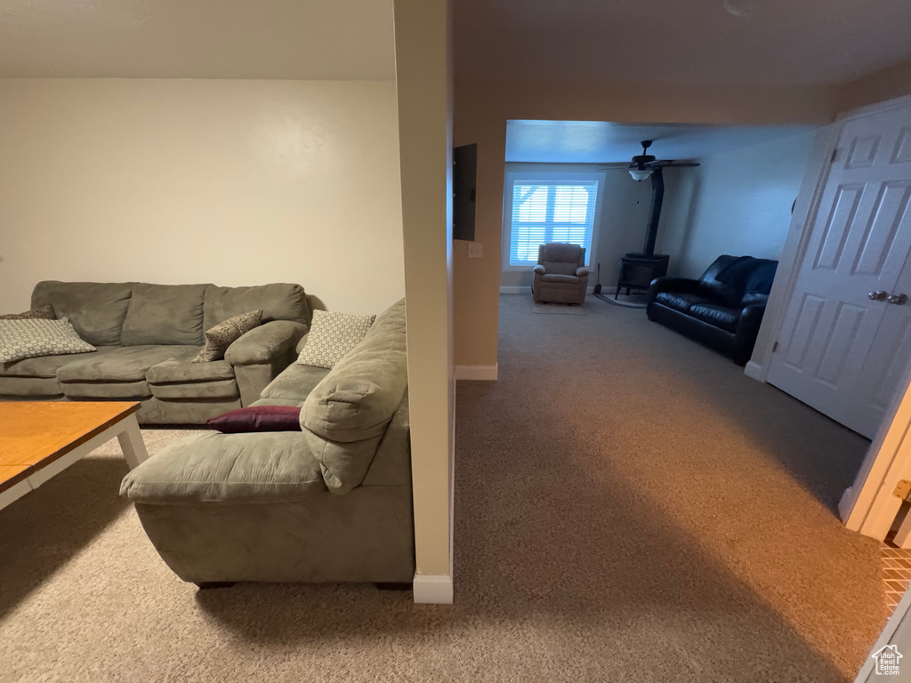 Carpeted living room with a wood stove and baseboards