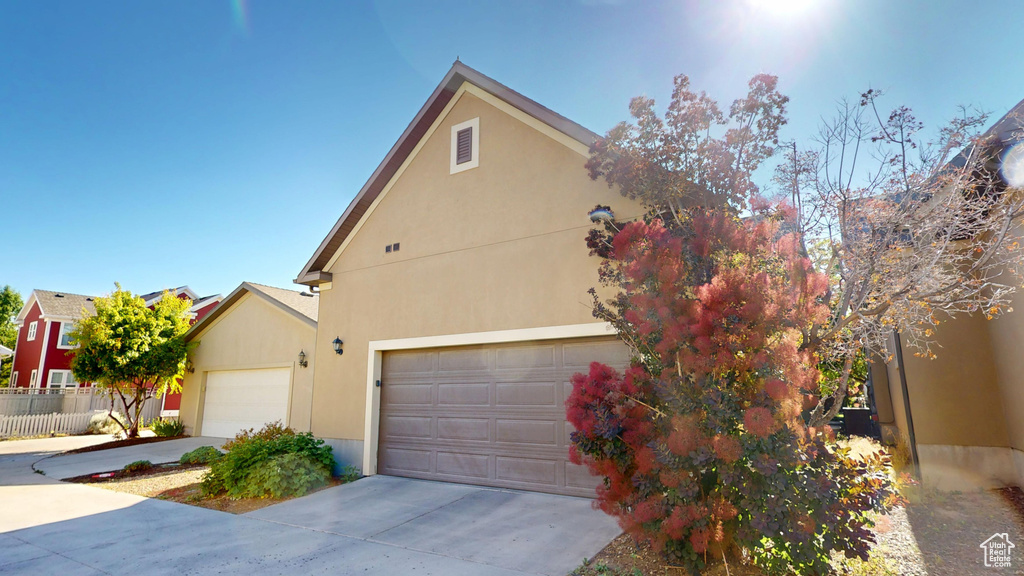 View of front of home featuring concrete driveway, stucco siding, and an attached garage