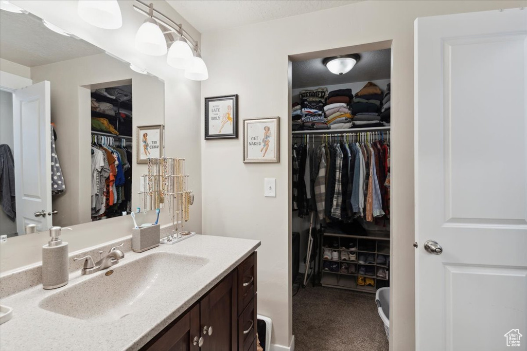 Bathroom with vanity and a spacious closet