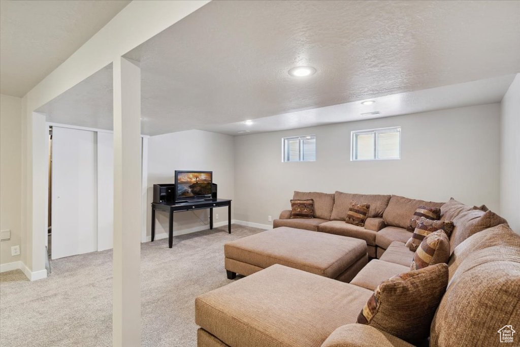 Living room with light colored carpet, baseboards, and recessed lighting