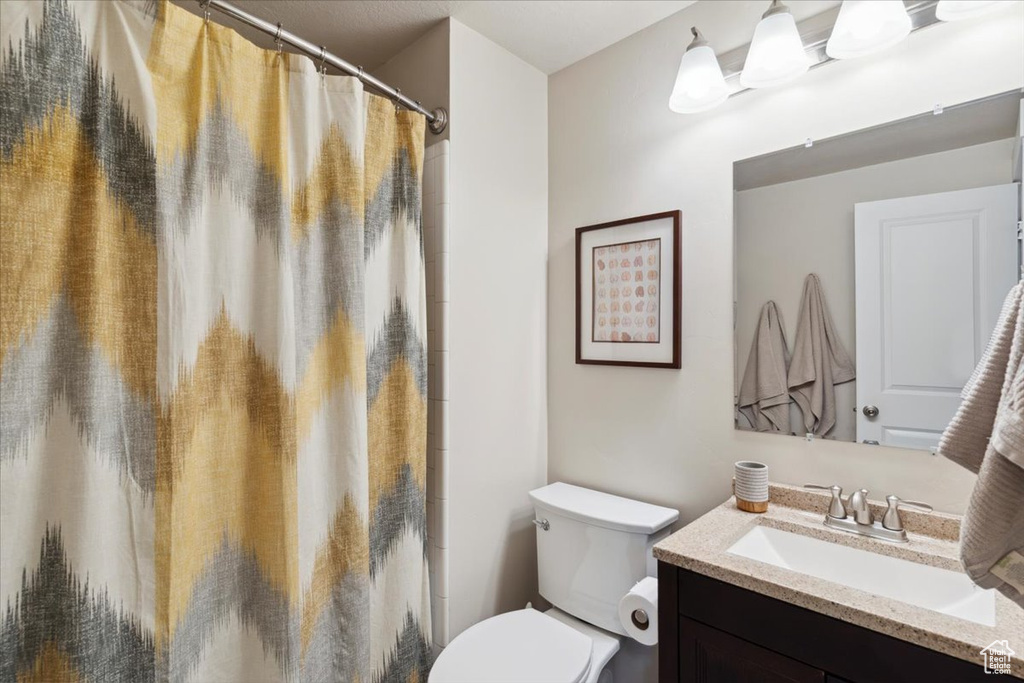 Bathroom featuring vanity, toilet, and a shower with curtain