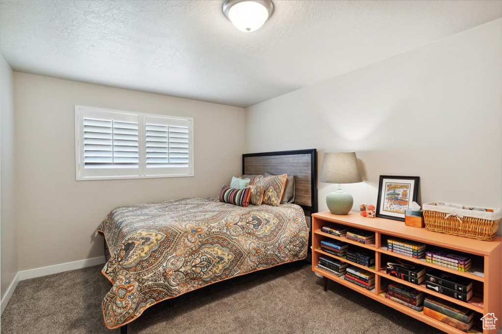 Carpeted bedroom featuring a textured ceiling and baseboards