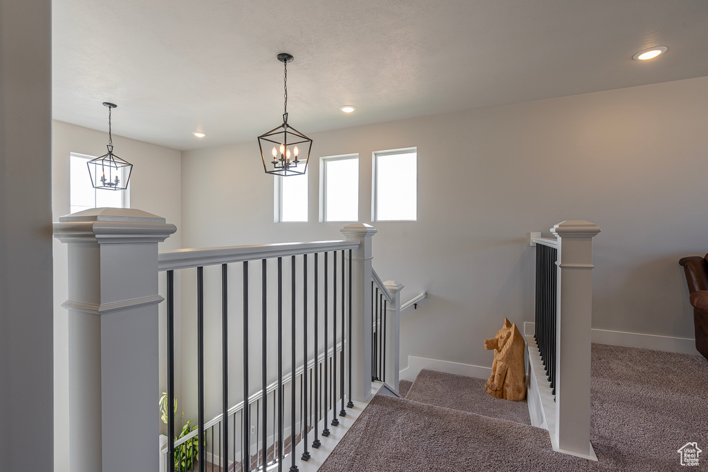 Stairway with carpet, baseboards, recessed lighting, and a chandelier