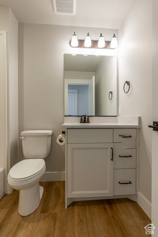 Bathroom featuring wood finished floors, vanity, and baseboards