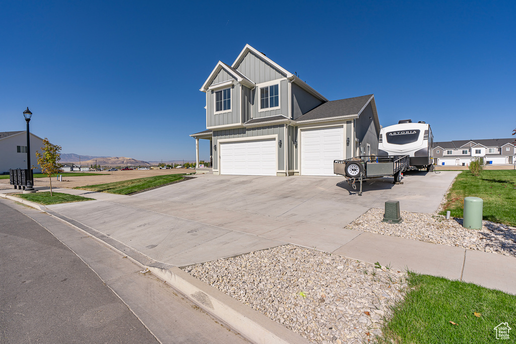 View of front of home with board and batten siding, concrete driveway, and a garage