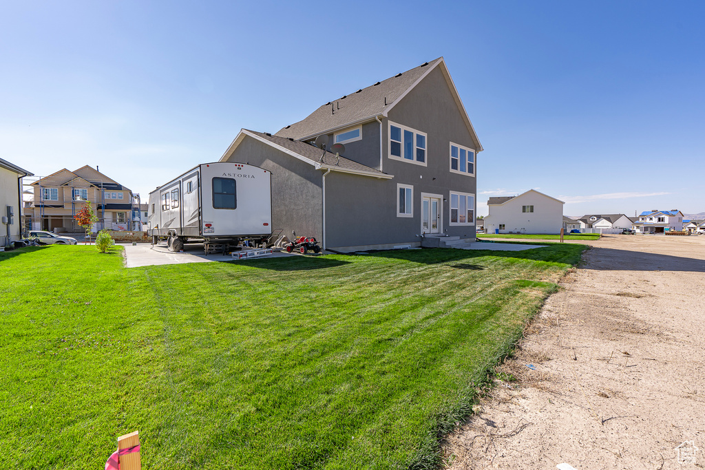 Rear view of house featuring a residential view and a yard
