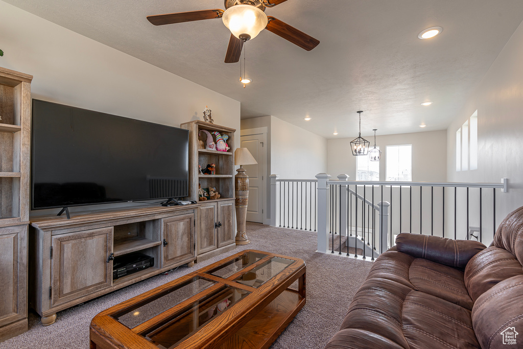 Living area with light colored carpet, a ceiling fan, and recessed lighting