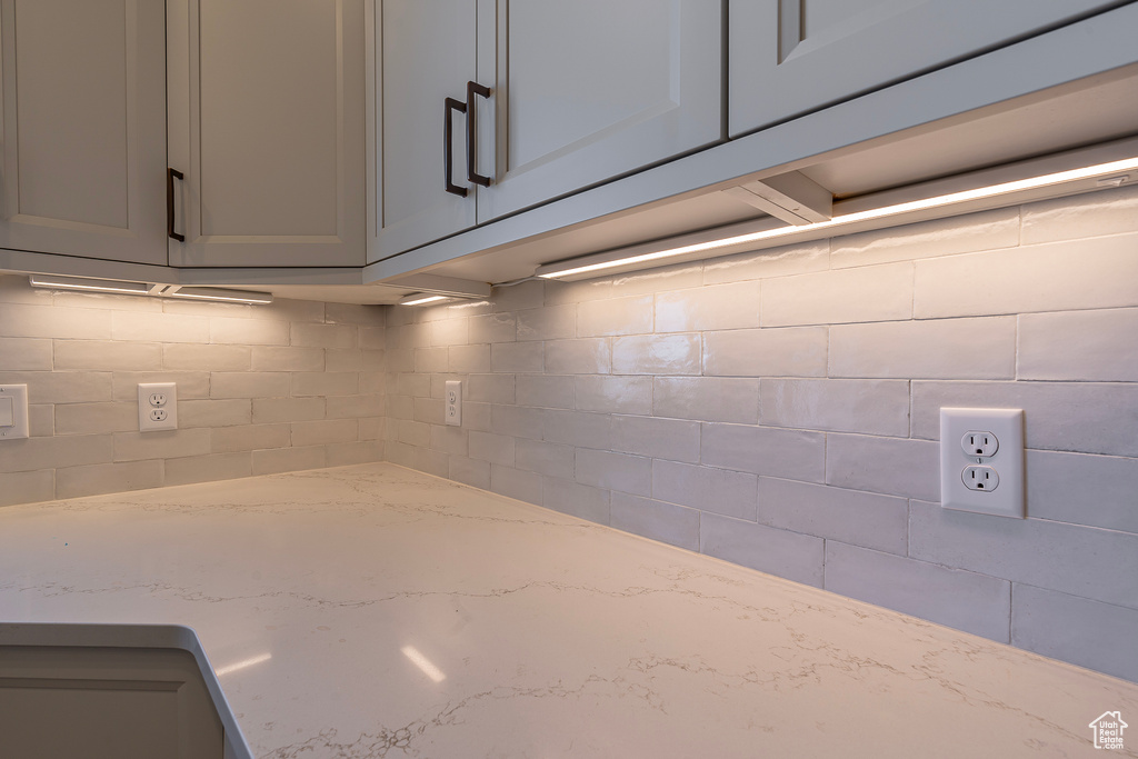 Kitchen view of gray cabinets and light stone countertops