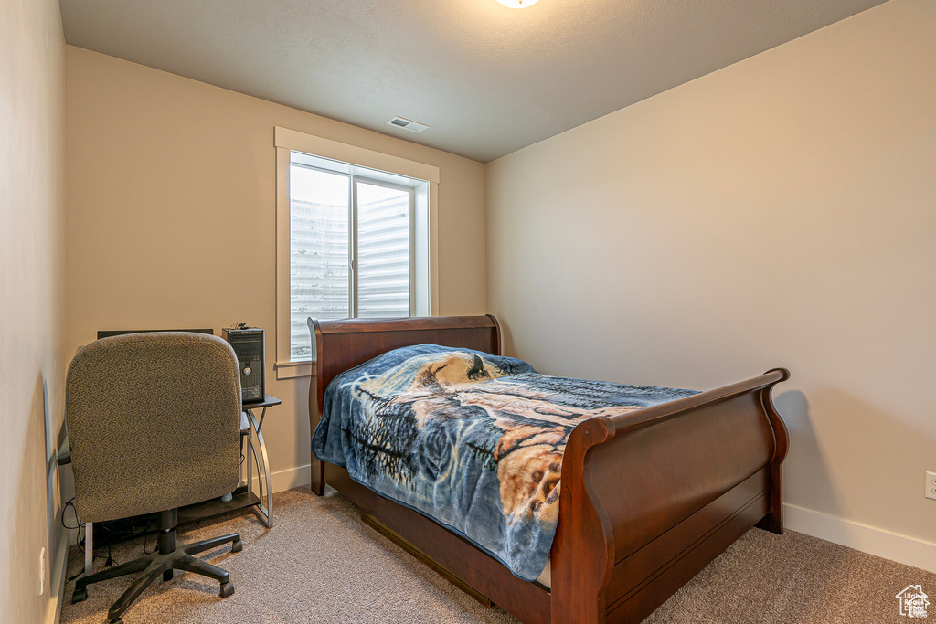 Bedroom featuring carpet and baseboards