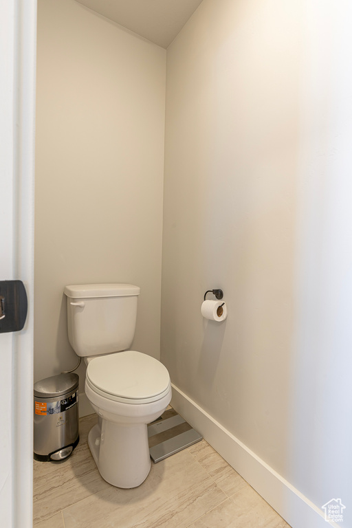 Bathroom featuring toilet, baseboards, and wood finished floors