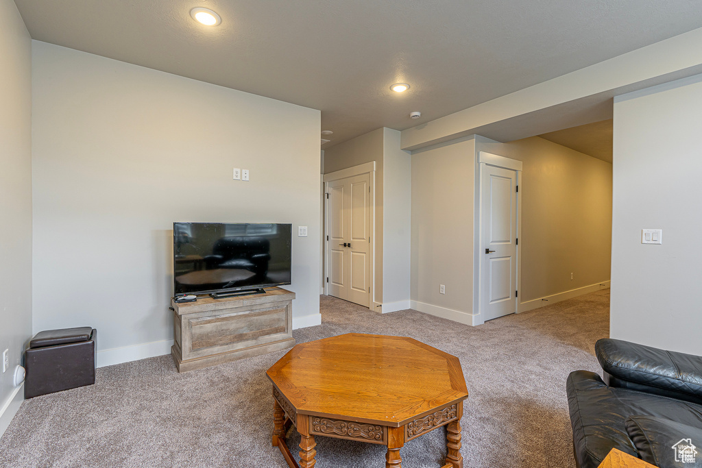 Carpeted living room with baseboards and recessed lighting