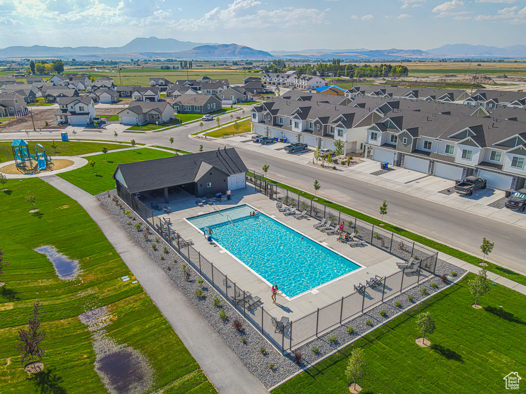 Aerial view of residential area with a pool and a mountain backdrop