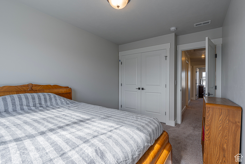 Carpeted bedroom with a closet and baseboards