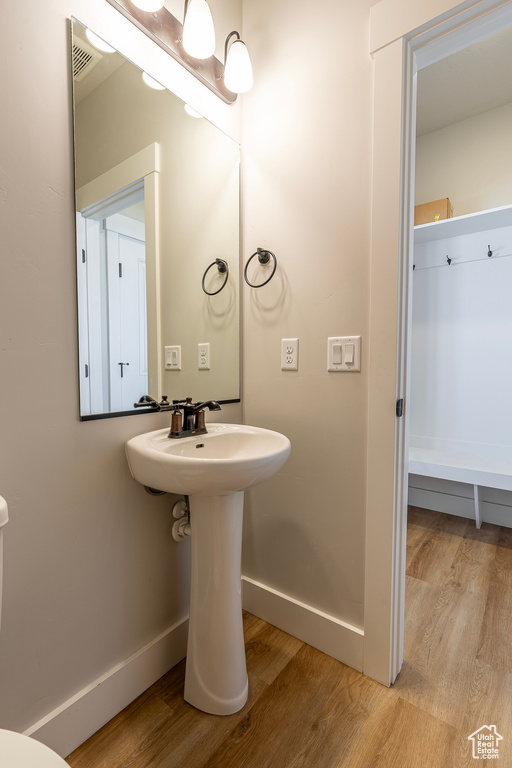 Bathroom featuring wood finished floors, baseboards, and a sink