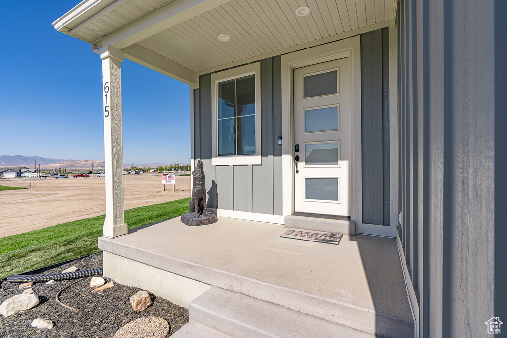 View of exterior entry with board and batten siding and a mountain view