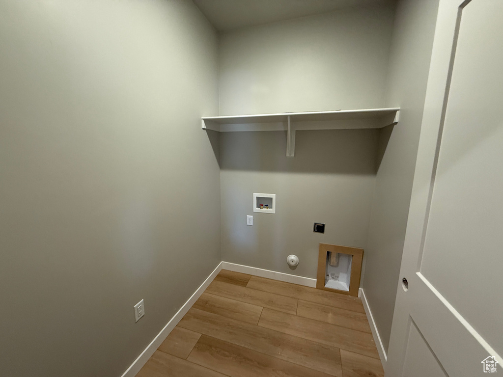 Laundry room featuring gas dryer hookup, hookup for an electric dryer, light wood-style floors, hookup for a washing machine, and baseboards