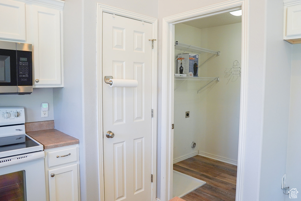 Laundry area featuring dark wood-type flooring