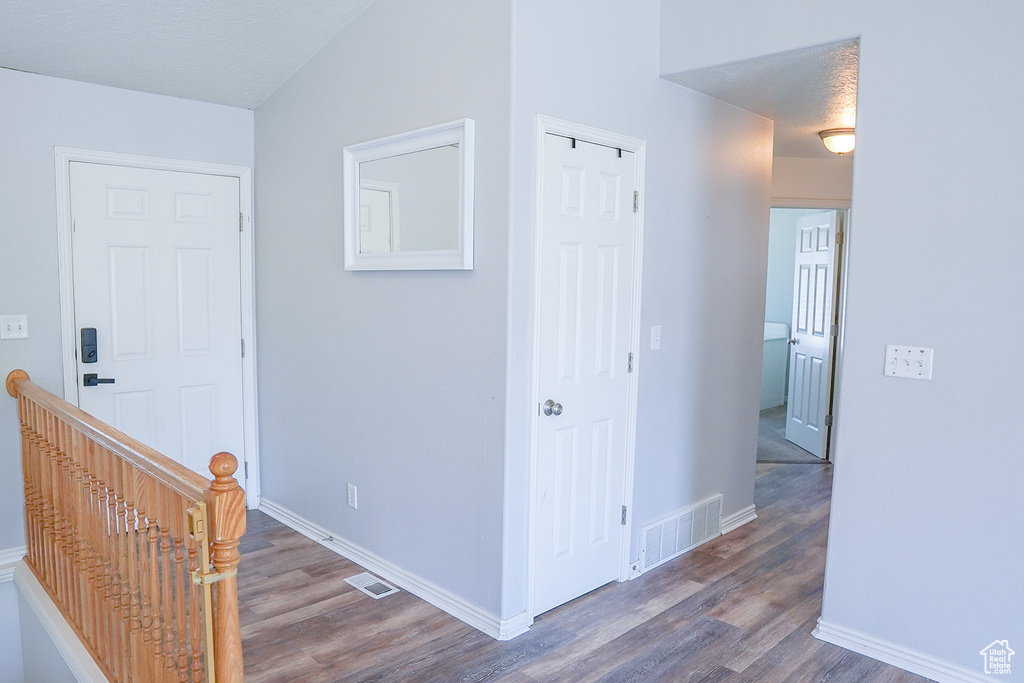 Corridor featuring wood finished floors, an upstairs landing, and baseboards