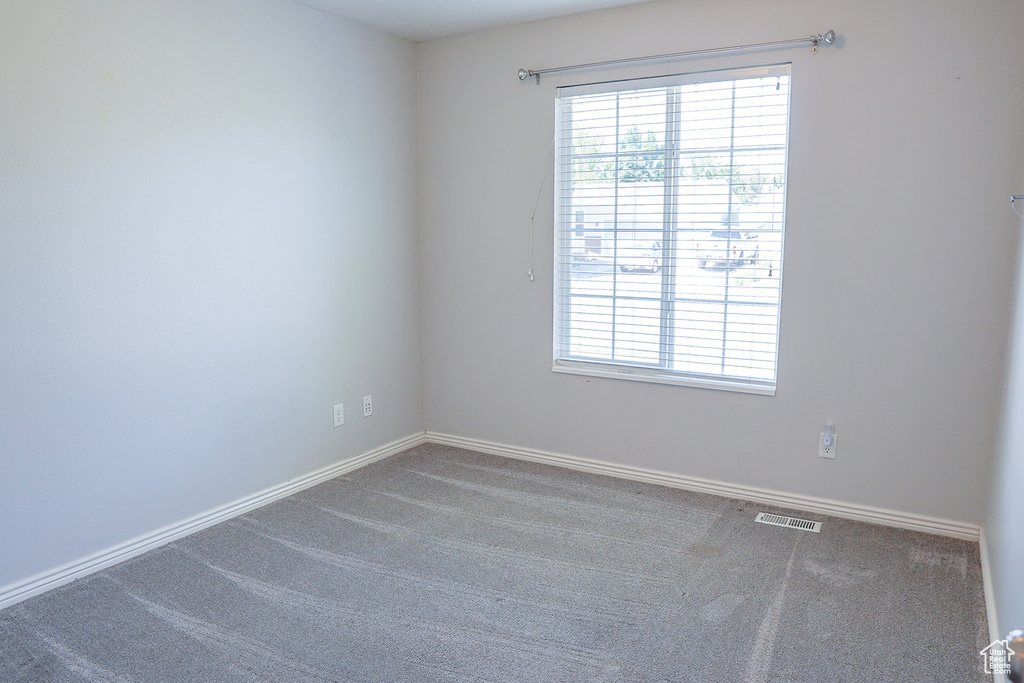 Carpeted empty room featuring baseboards