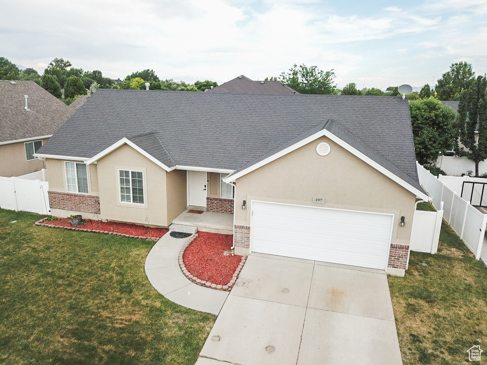 View of front facade with brick siding, a garage, stucco siding, a shingled roof, and concrete driveway