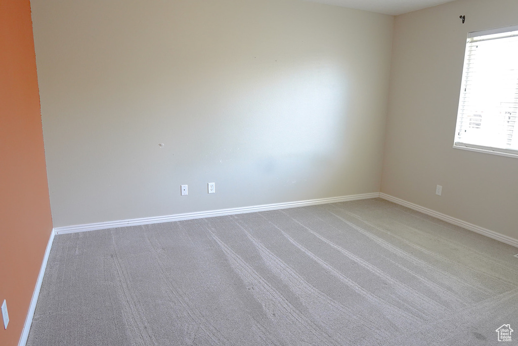 Unfurnished room featuring light colored carpet and baseboards