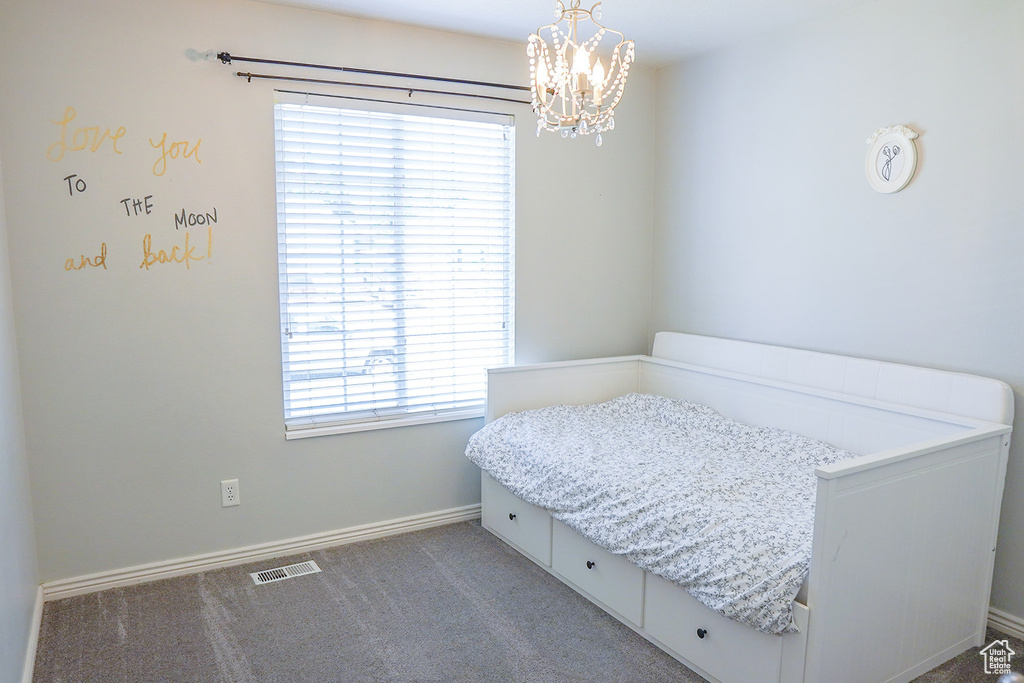 Bedroom featuring a chandelier, carpet flooring, and baseboards