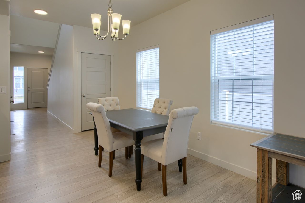 Dining room with a chandelier, baseboards, light wood-style flooring, and recessed lighting