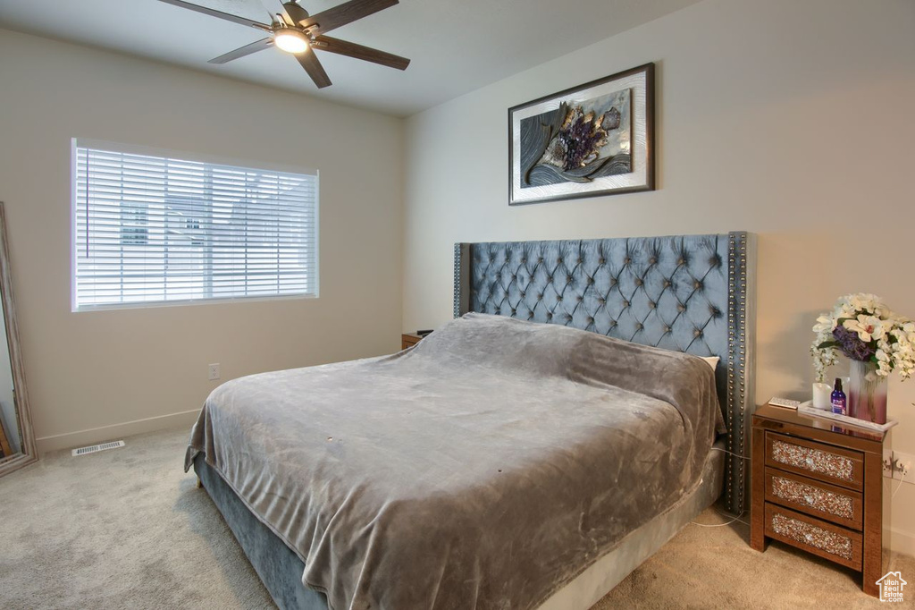 Carpeted bedroom featuring a ceiling fan and baseboards