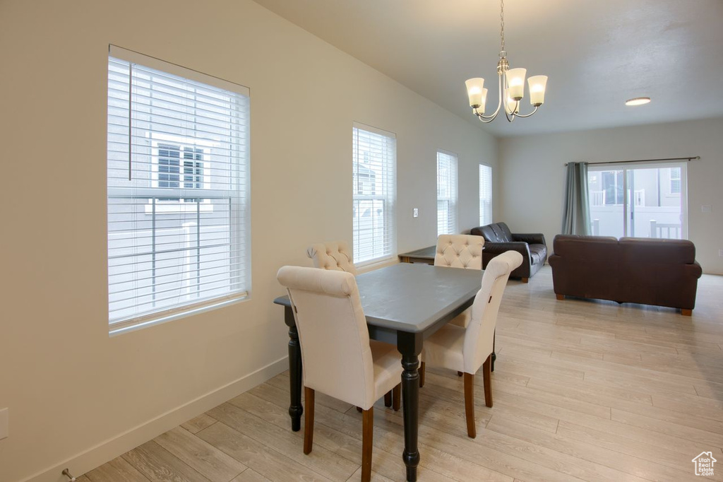 Dining space featuring a chandelier, baseboards, and light wood finished floors