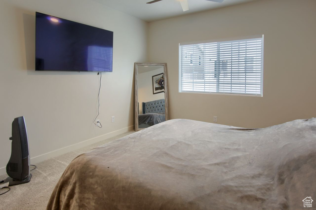 Carpeted bedroom featuring baseboards and a ceiling fan