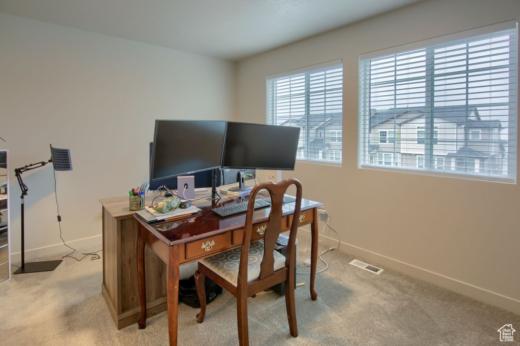 Home office featuring light colored carpet and baseboards