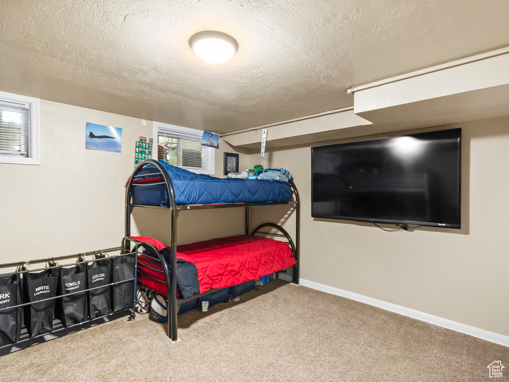 Carpeted bedroom with a textured ceiling and baseboards
