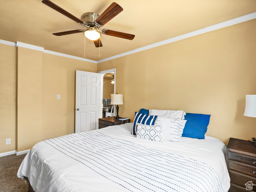 Carpeted bedroom featuring ornamental molding and ceiling fan