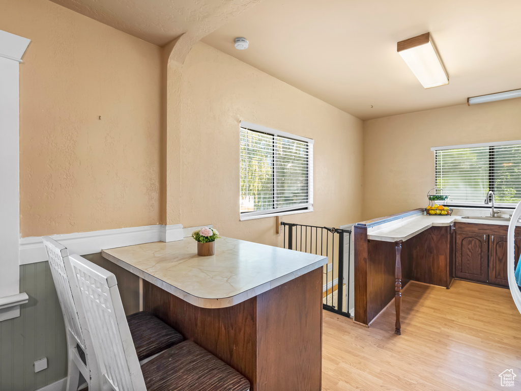Office space with light wood finished floors and a sink