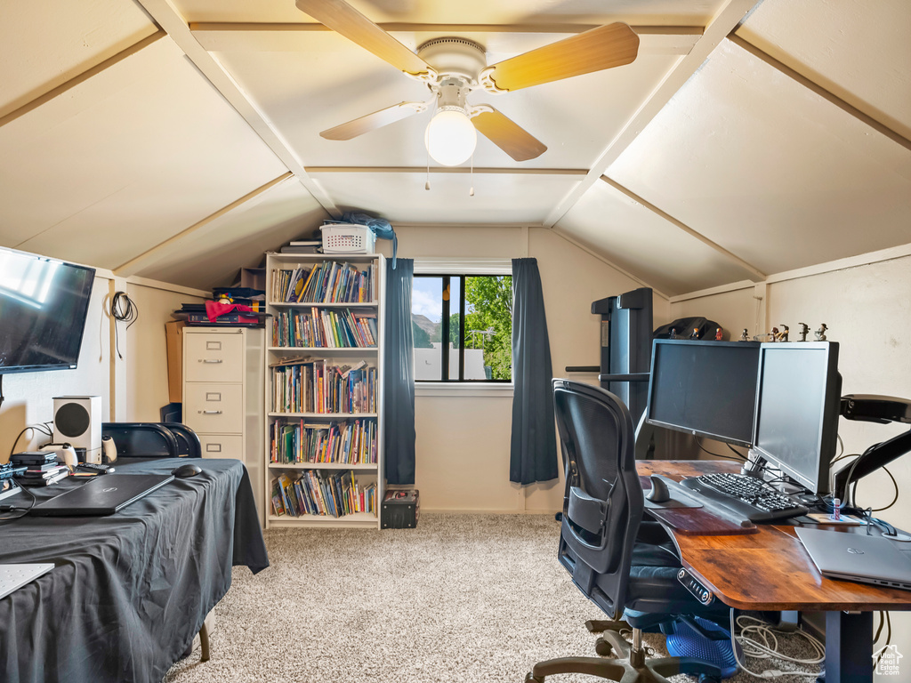 Office space with vaulted ceiling, carpet flooring, and a ceiling fan