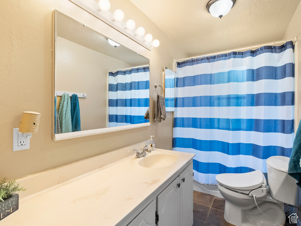 Bathroom with vanity, tile patterned flooring, and a shower with curtain