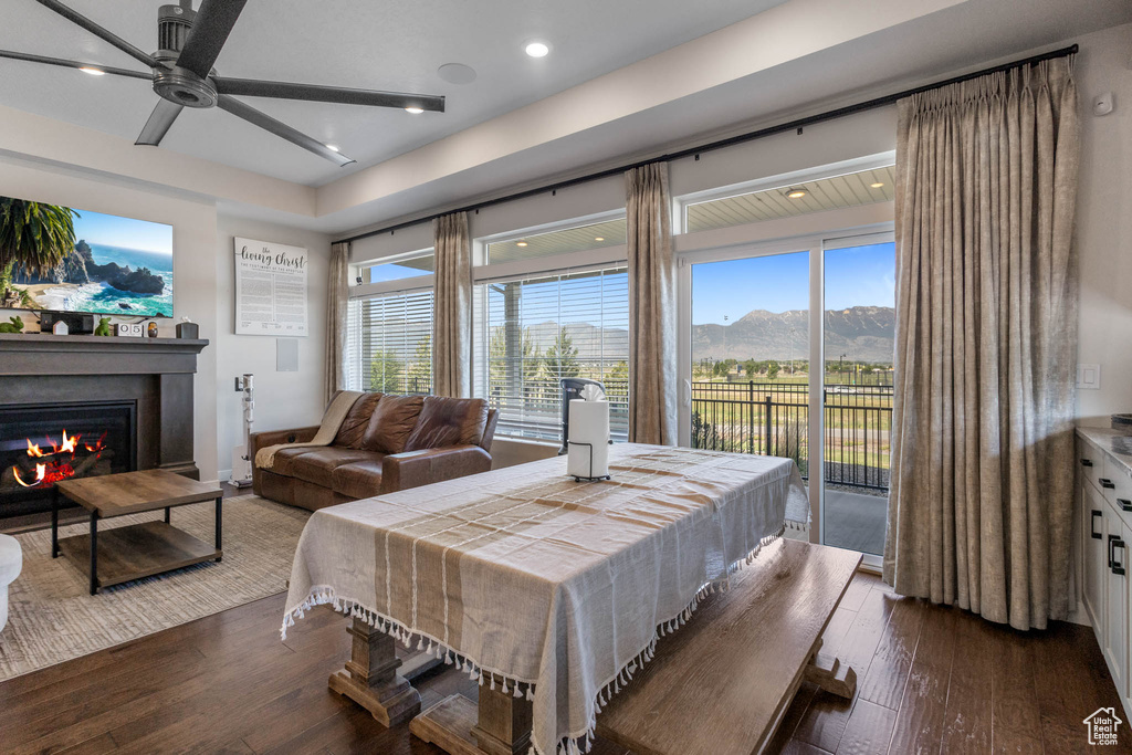Bedroom with access to exterior, dark wood-type flooring, a glass covered fireplace, recessed lighting, and multiple windows