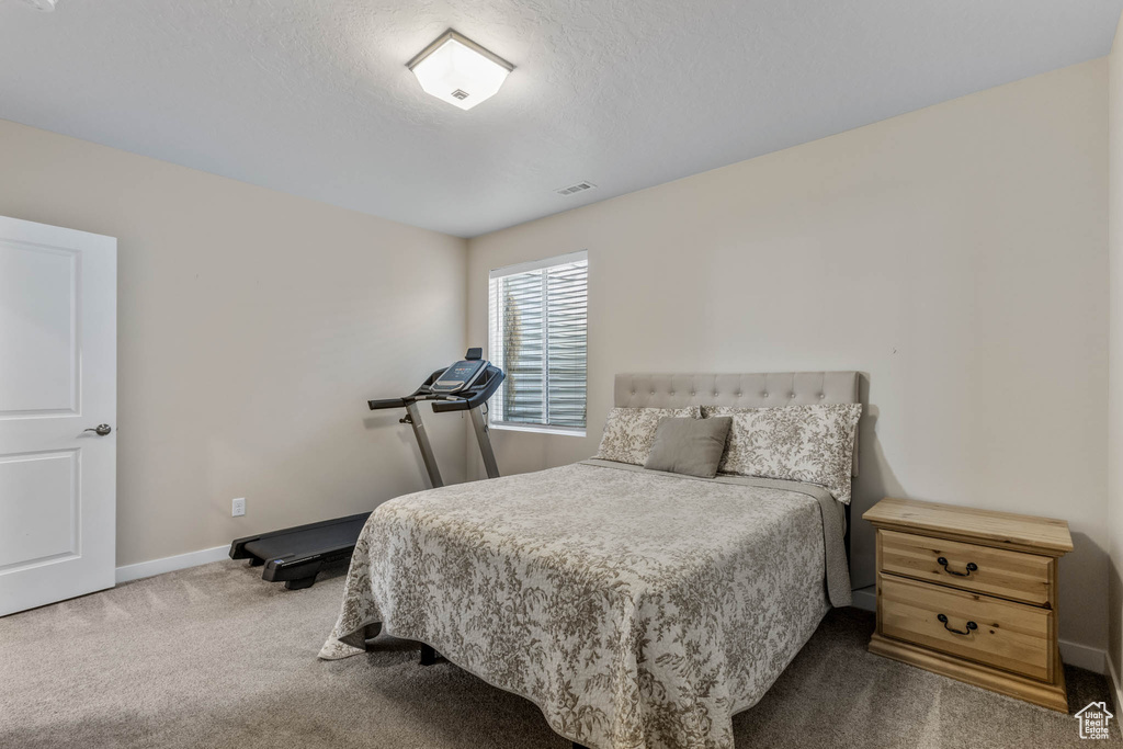 Bedroom with dark carpet and baseboards