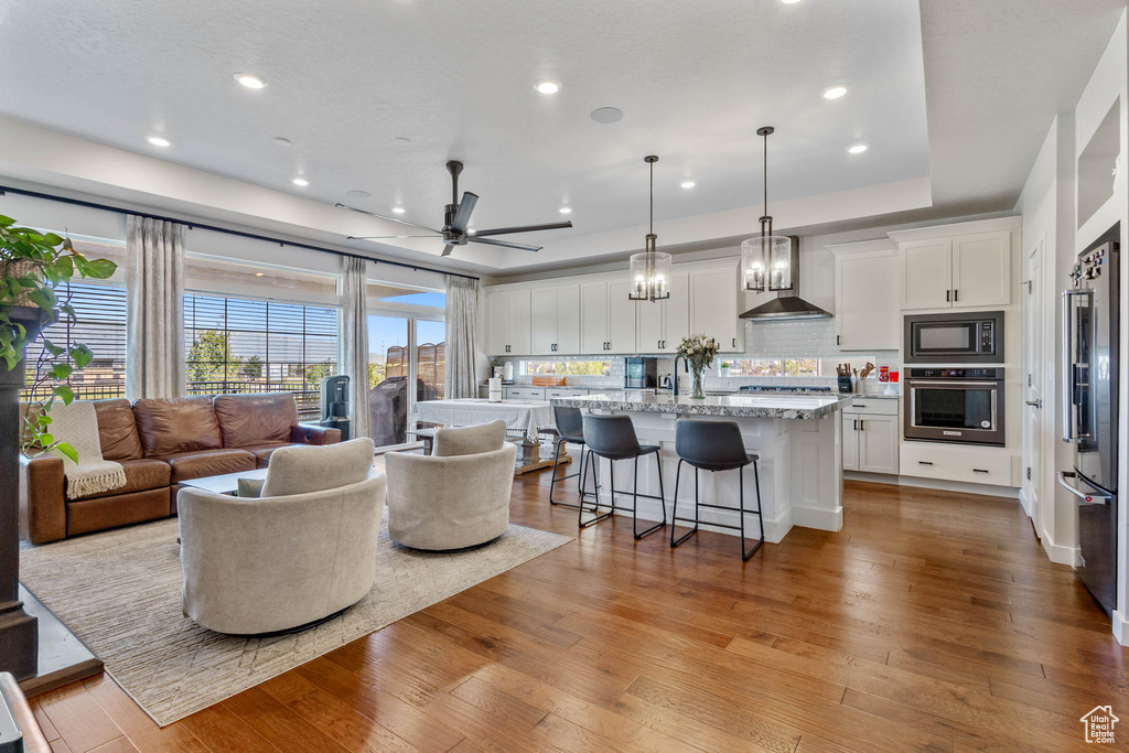 Living room featuring ceiling fan, hardwood / wood-style floors, and recessed lighting