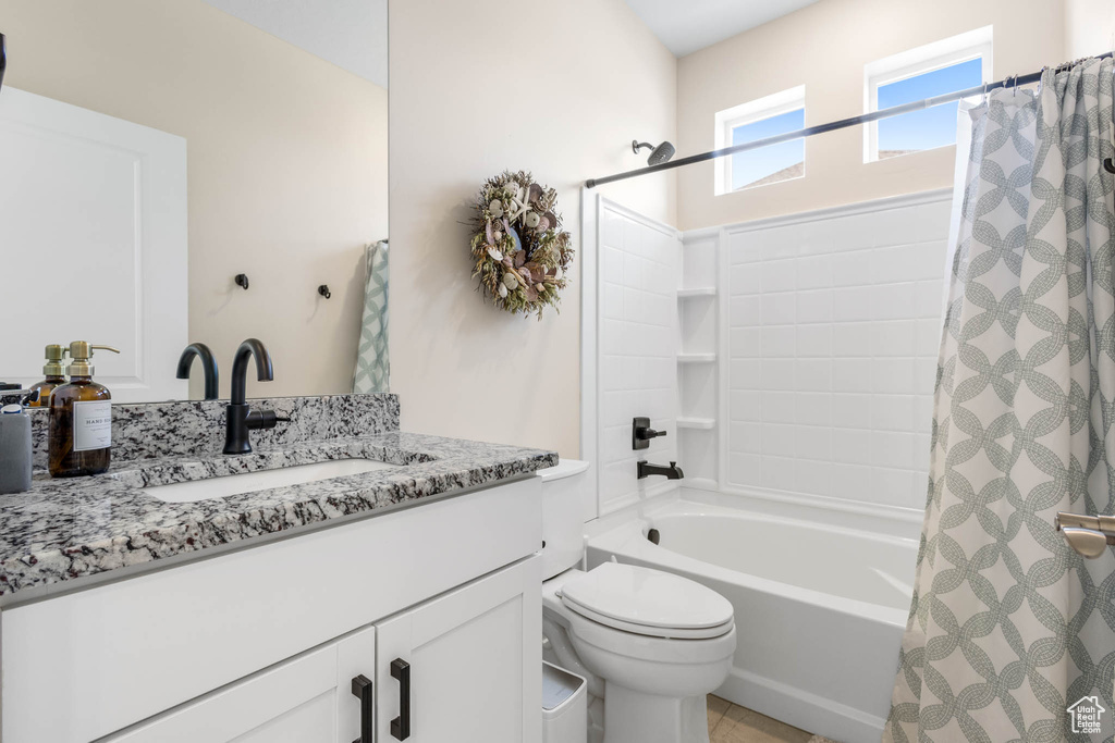 Full bath with vanity, shower / bath combination with curtain, and toilet